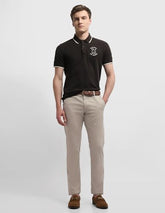 Arrow Sport men's Bronson slim fit chino pants in casual tan color, featuring a modern art-inspired design on the fabric.