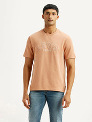 Levi's men's embroidered peach crew neck T-shirt with short sleeves, featuring colorful embroidery on the front.