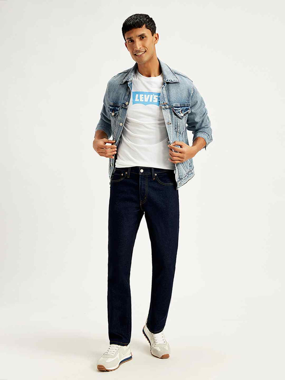 Levi's men's 511 blue slim fit mid-rise jeans shown in a style shot, featuring a classic five-pocket design and modern fit.