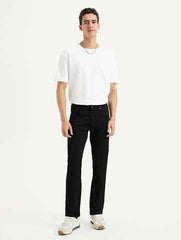 Levi's men's black slim fit mid-rise jeans displayed on a model, showcasing the classic five-pocket design and modern fit.