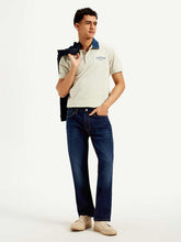 Levis men's jeans in dark wash with classic five-pocket design, slim fit style, shown on a hanger.