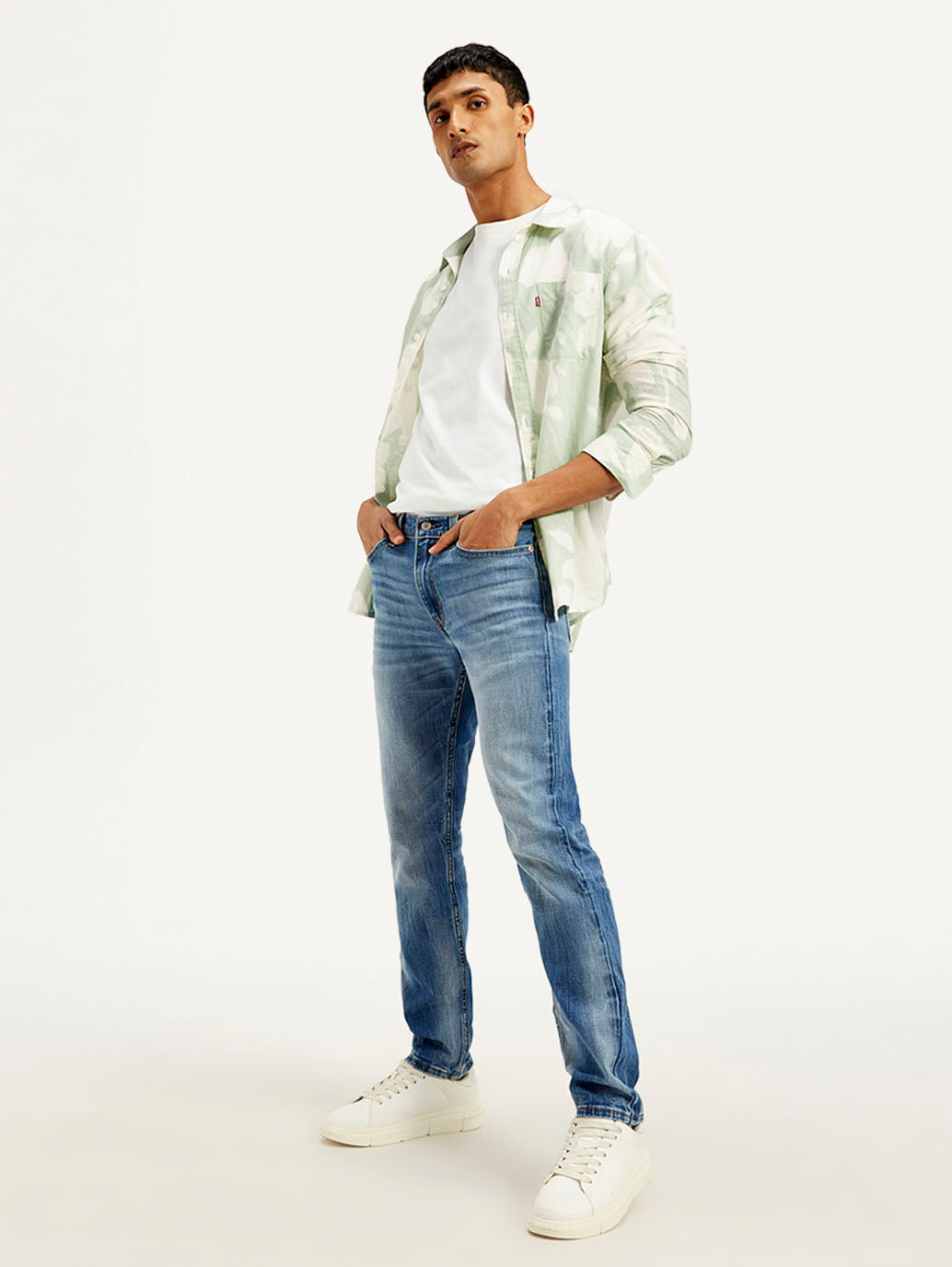 Light blue Levi's men's 511 slim fit mid-rise jeans displayed on a model in a styleshot image.