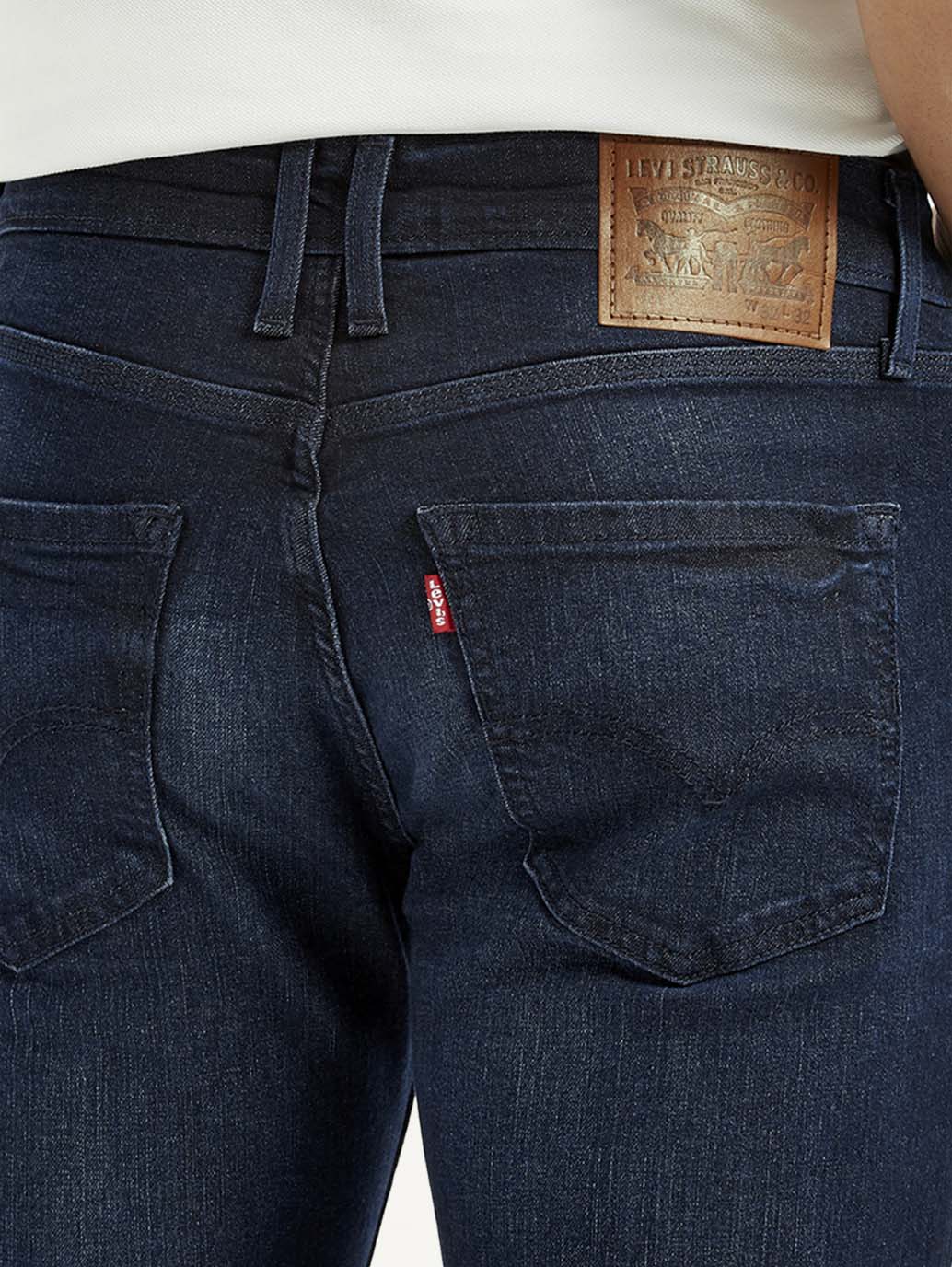 Levi's men's dark blue slim fit mid-rise jeans with detailed stitching and classic five-pocket design.