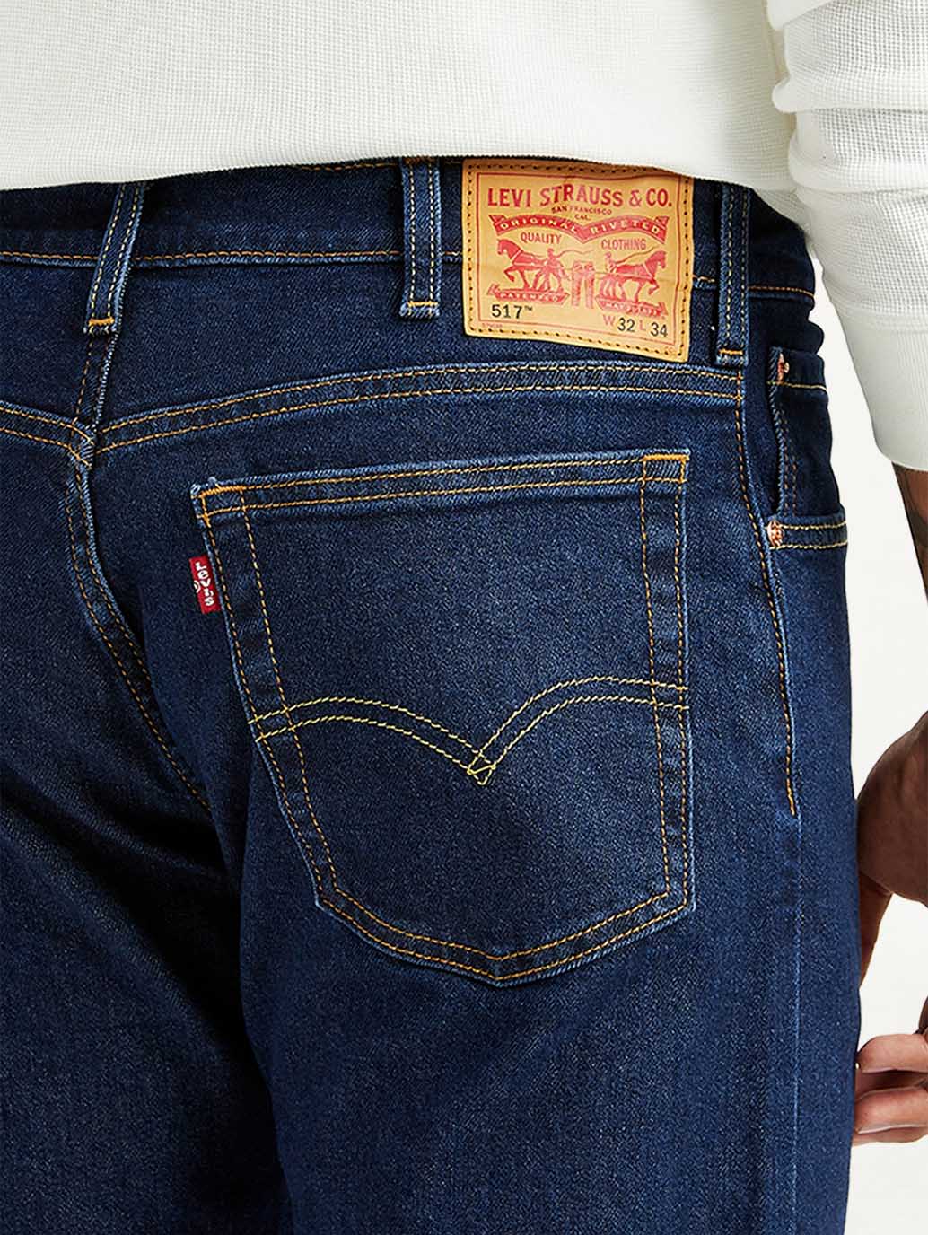 Levis men's dark blue 517 bootcut mid-rise jeans, denim fabric, detailed stitching, and classic five-pocket design.