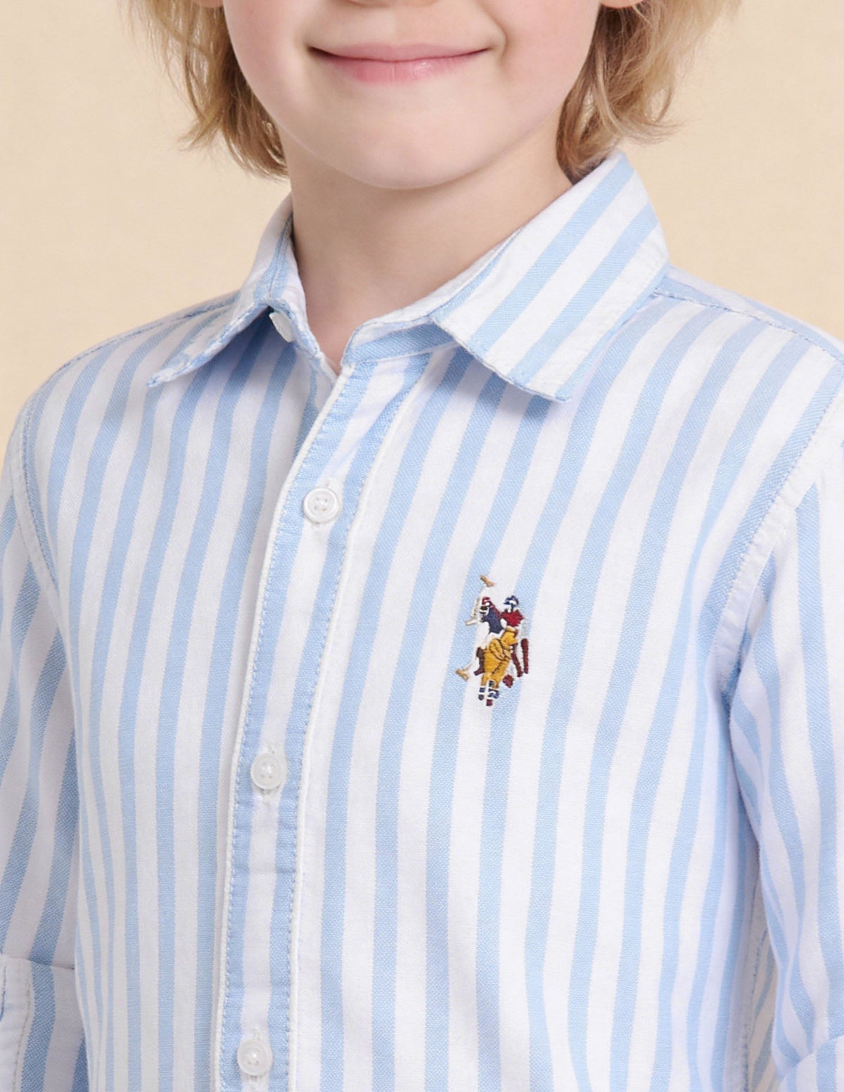 U.S. Polo Boys long-sleeve blue shirt, casual style for kids, with collar and button front, displayed on a hanger.