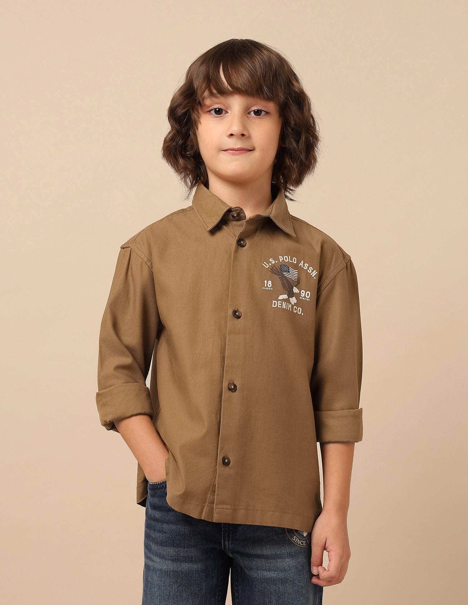 U.S. Polo boys' shirt featuring a classic design, with short sleeves and a collar, displayed on a hanger.